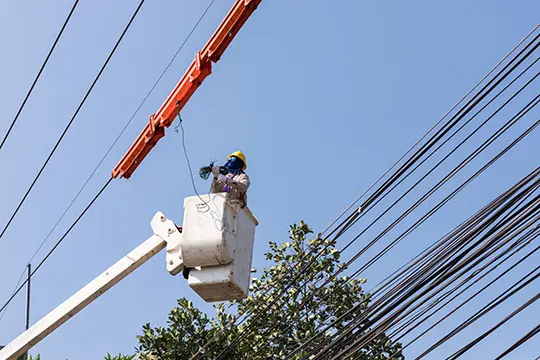 Man in cherry picker repairing electrical line
